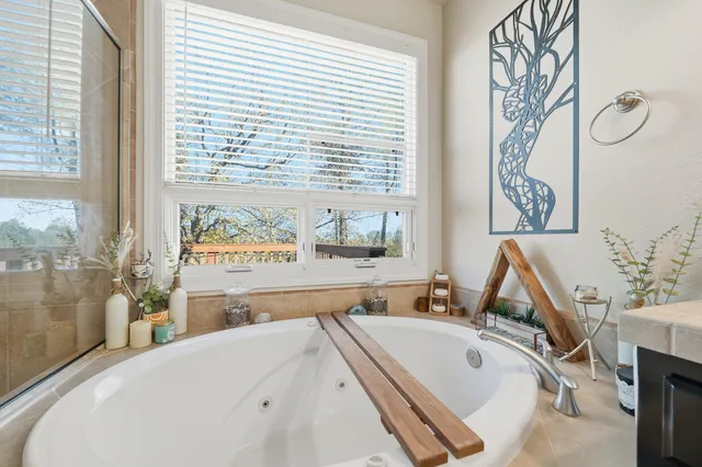 a bathroom with a tub a sink and a large mirror