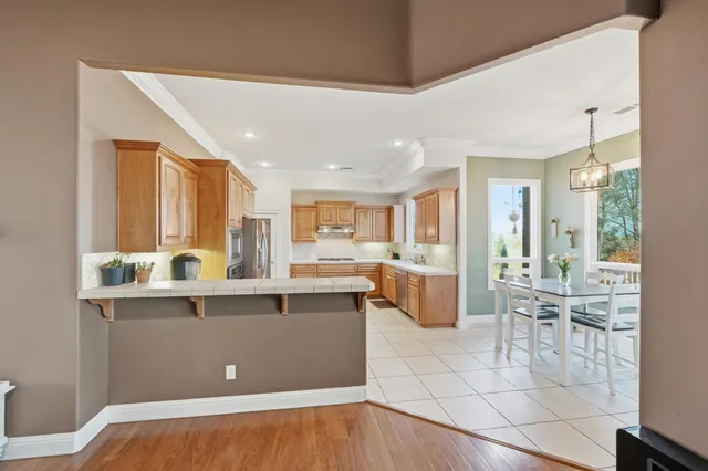 a room with stainless steel appliances kitchen island granite countertop a refrigerator and cabinets