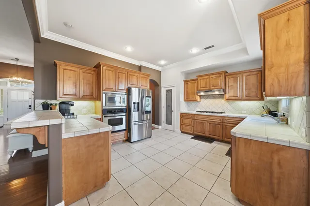 a kitchen with stainless steel appliances a stove refrigerator sink and cabinets