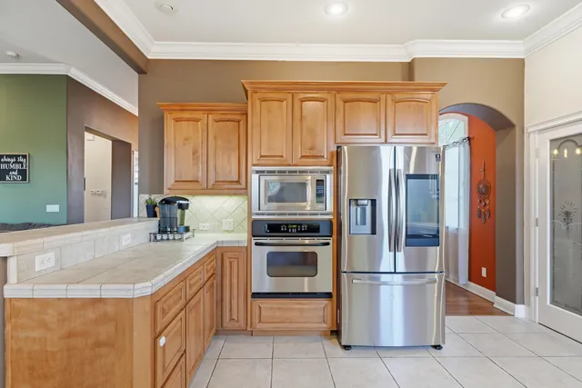 a kitchen with stainless steel appliances granite countertop a refrigerator and a sink