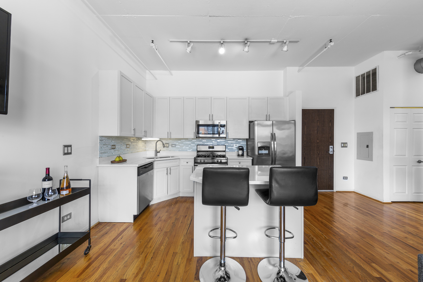 950 West Monroe Street, Unit 616 Chicago, IL 60607 - Photo 12 of 28 a kitchen with stainless steel appliances a stove a refrigerator and white cabinets with wooden floor