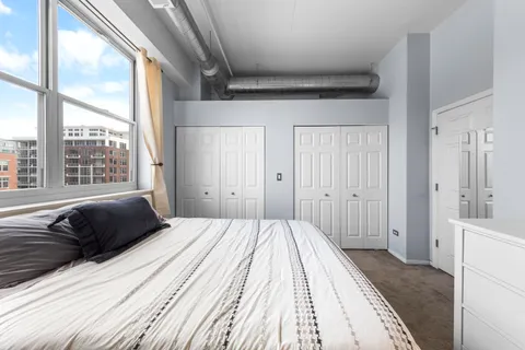 a bedroom with a bed and a large window