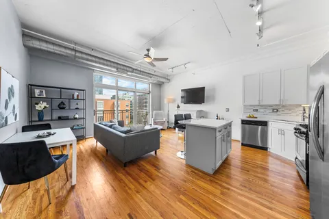 a large living room with stainless steel appliances granite countertop a couch and a view of living room