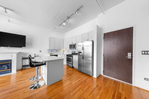 a kitchen with a refrigerator and a stove top oven
