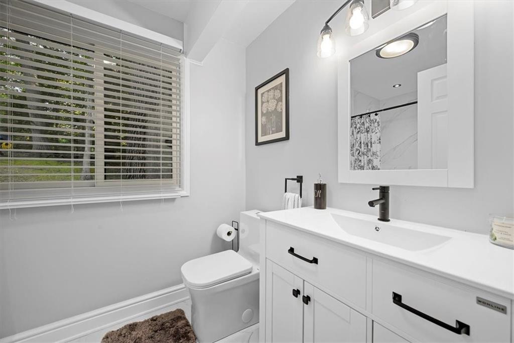 228 Foxglove Road Baden, PA 15005 - Photo 10 of 25 a bathroom with a sink a toilet and mirror