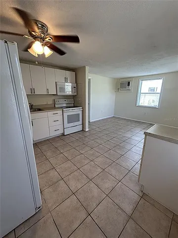 a kitchen with granite countertop a sink cabinets and stainless steel appliances
