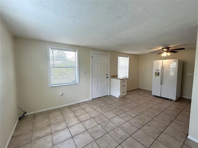 a view of an empty room with window and cabinet