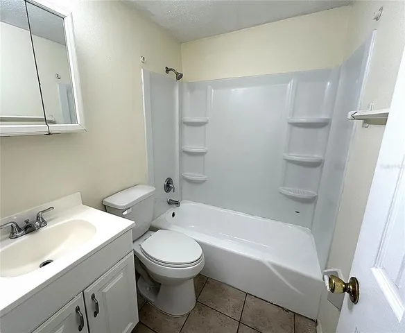 a bathroom with a bathtub shower sink vanity and toilet