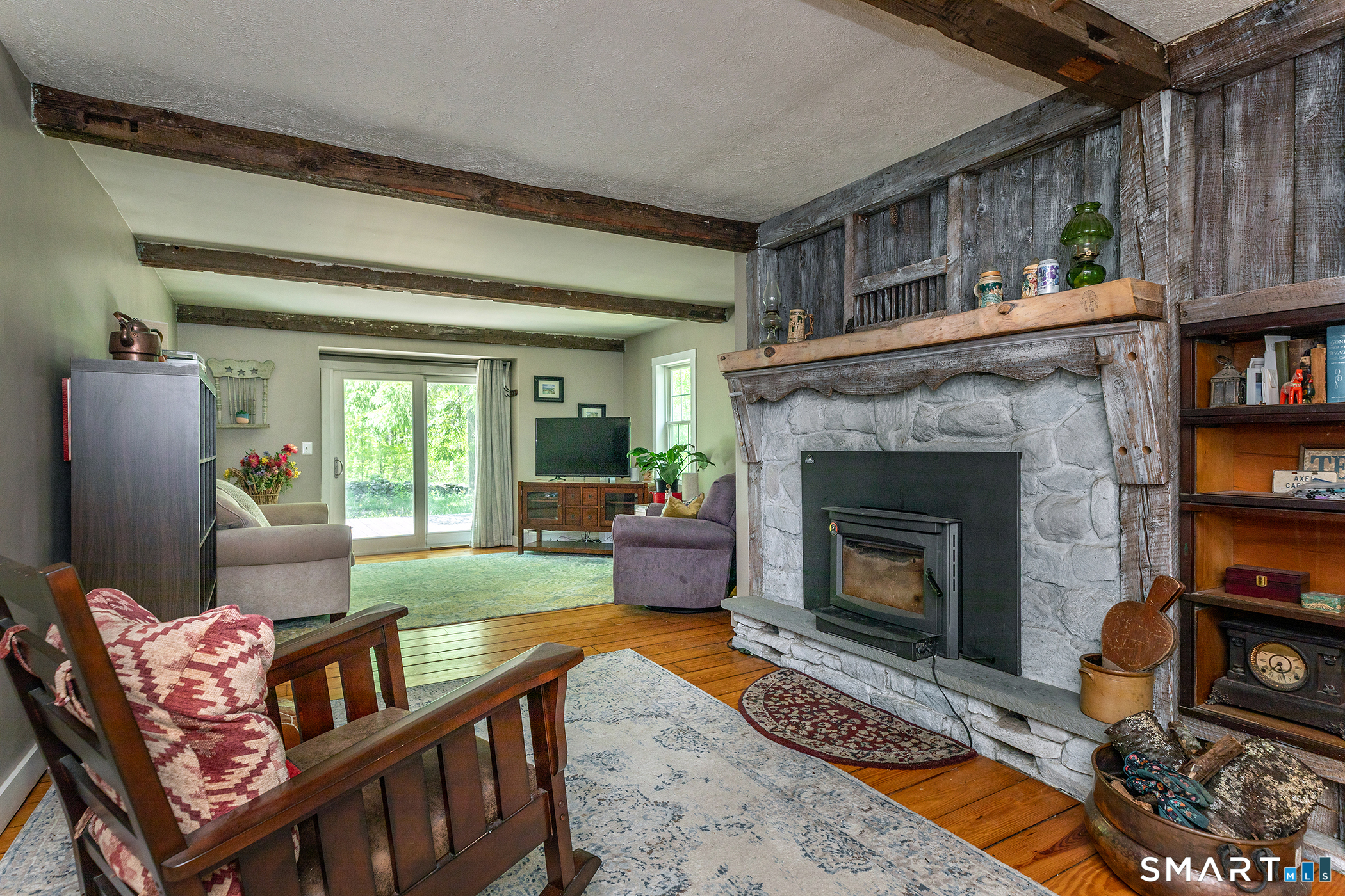 25 Bald Hill Road Kent, CT 06785 - Photo 11 of 38 This expansive living room highlights the rich character of wide board floors & a magnificent stone fireplace. Anchoring the home's open layout, this spacious room features a wide slider that opens directly to the back deck for indoor /outdoor living