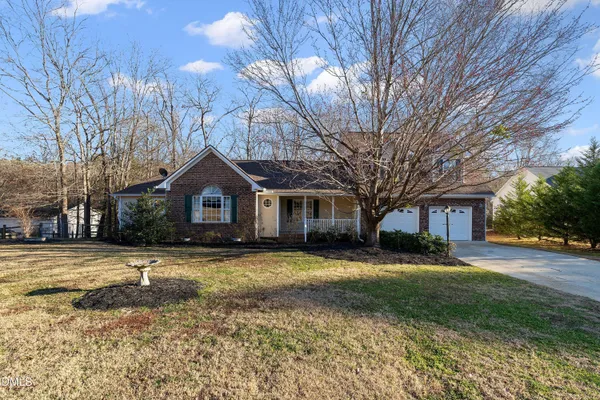 a front view of a house with a yard and trees