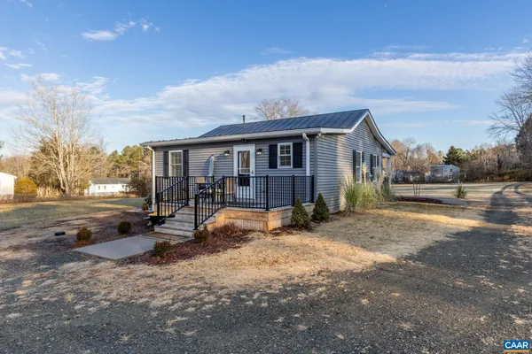 a view of a house with a yard and a wooden fence