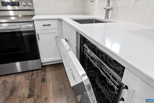 a kitchen with stainless steel appliances granite countertop a sink a stove and cabinets