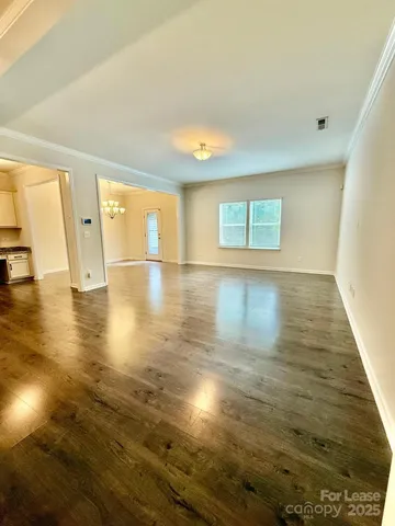 a view of a room with wooden floor and chandelier