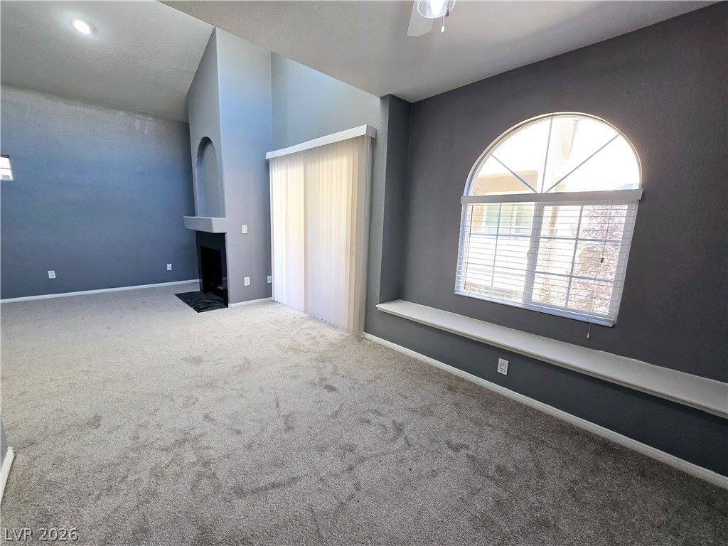 9325 West Desert Inn Road, Unit 229 Las Vegas, NV 89117 - Photo 3 of 17 High ceilings and a fireplace anchor this open living area highlighted by arched window detail.