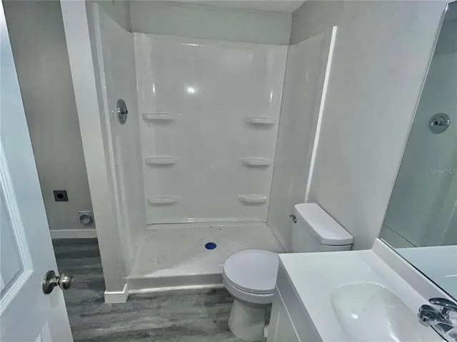 a bathroom with a sink a toilet and shower