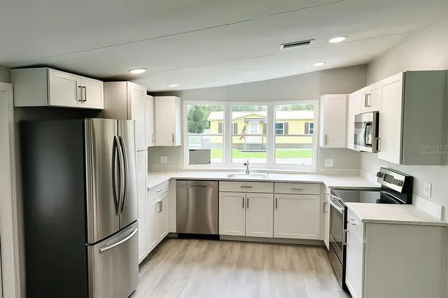 a kitchen with stainless steel appliances a refrigerator sink and microwave