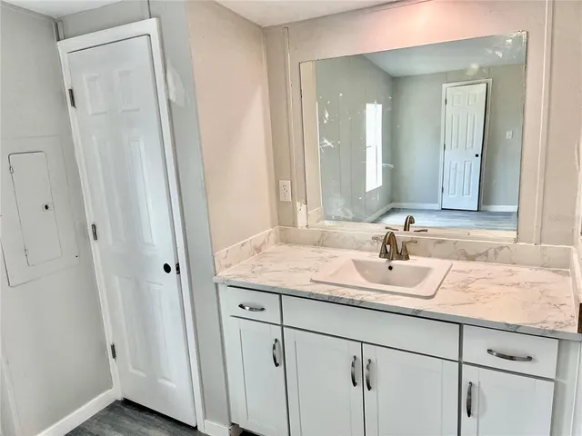 a bathroom with a granite countertop sink and a mirror