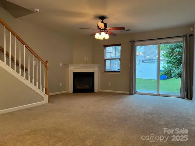 a view of an empty room with a fireplace and a window