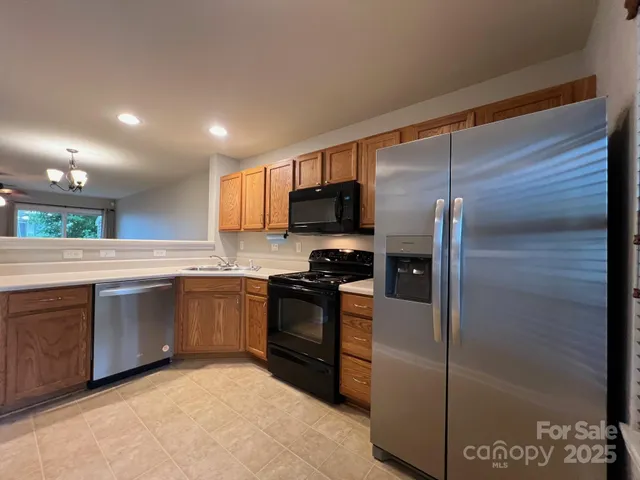 a kitchen with stainless steel appliances granite countertop a refrigerator and a sink