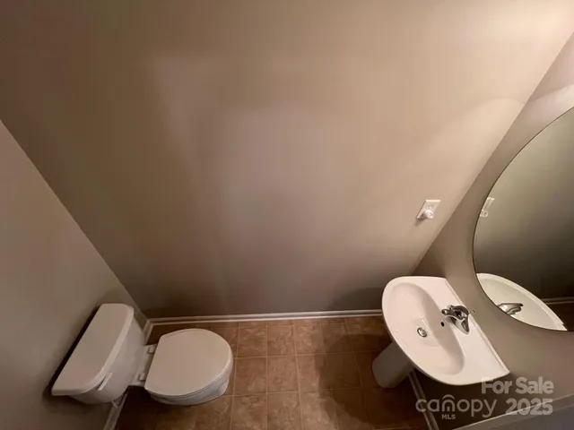 a bathroom with a toilet mirror and sink