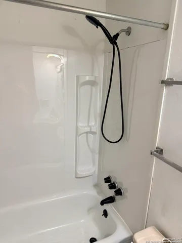 a bathroom with a bath tub with a shower