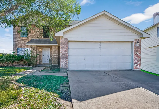 a front view of a house with a yard and garage