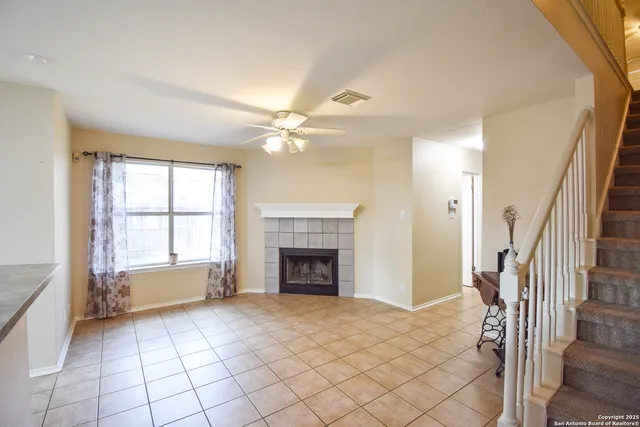 a view of an empty room with fireplace and a window