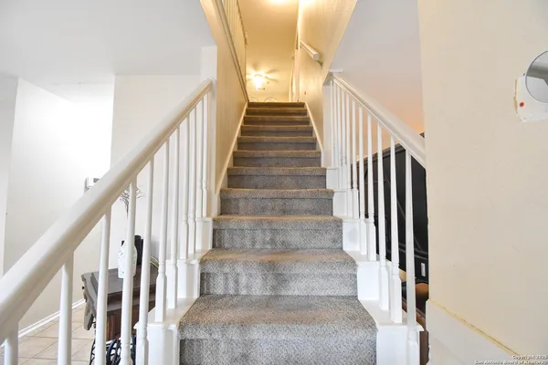 a view of staircase with wooden floor and white walls