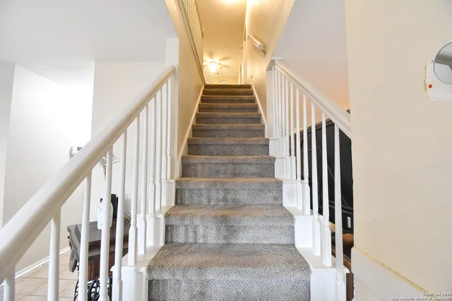 a view of staircase with wooden floor and white walls