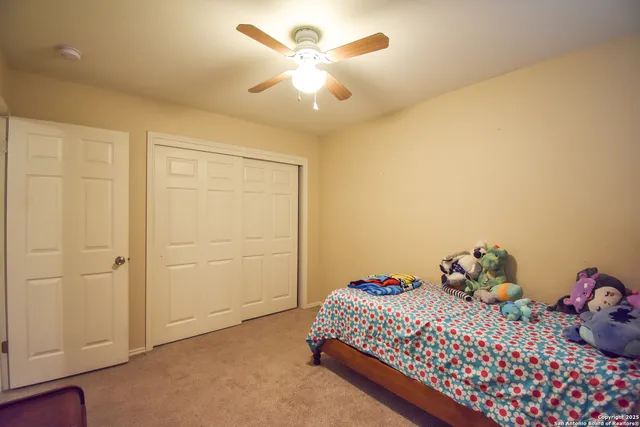 a bedroom with a bed and a chandelier fan