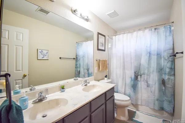 a bathroom with a sink toilet a mirror and shower