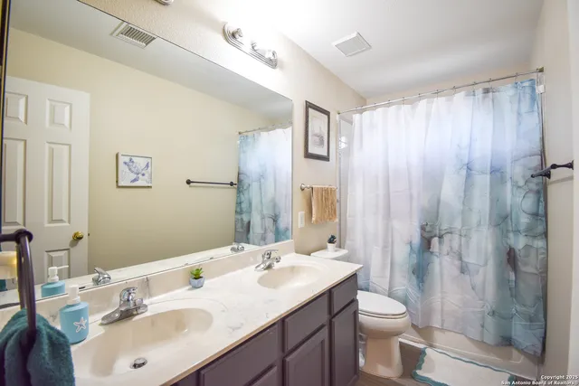 a bathroom with a sink toilet a mirror and shower