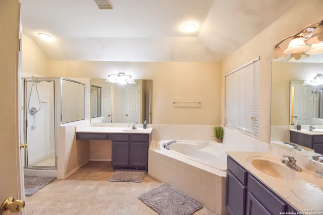 a bathroom with a tub a sink and mirror