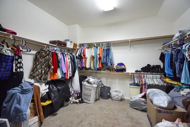 a view of walk in closet with clothes and shoes