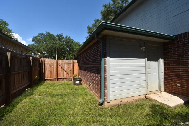 a backyard of a house with a small barn and wooden fence