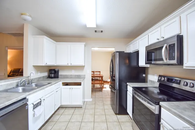 a kitchen with stainless steel appliances granite countertop a refrigerator stove and sink