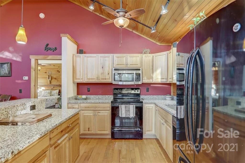 263 Summer Circle Clyde, NC 28721 - Photo 11 of 36 a kitchen with stainless steel appliances granite countertop a sink stove and refrigerator