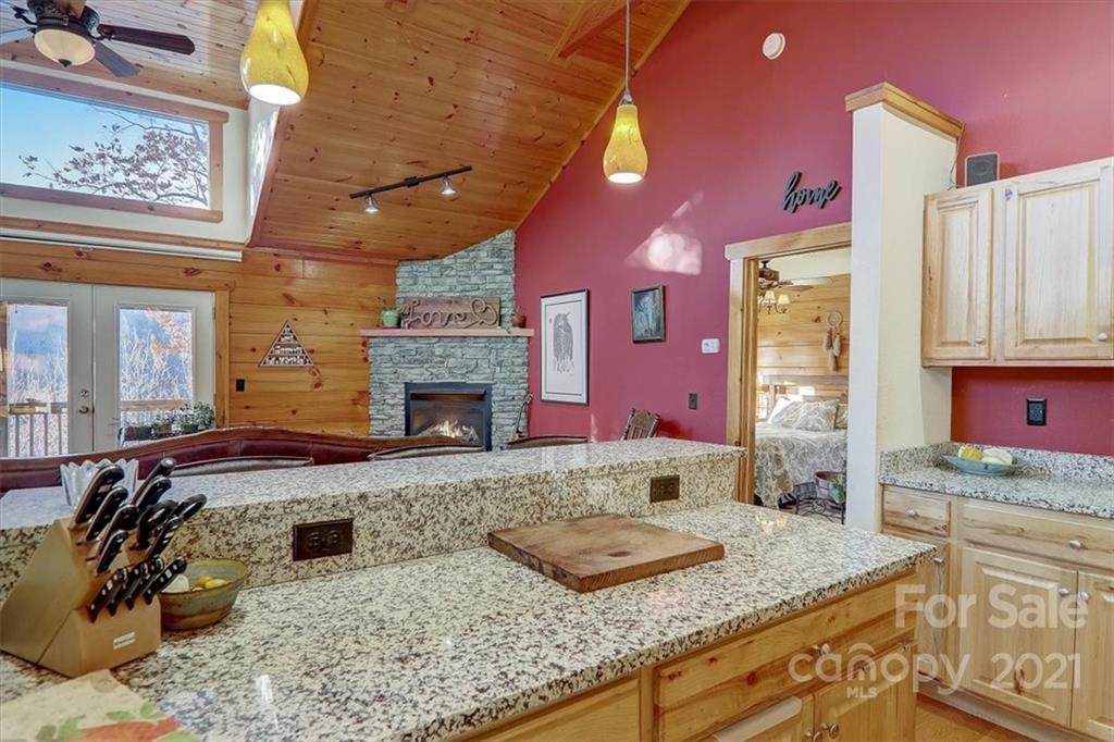 263 Summer Circle Clyde, NC 28721 - Photo 12 of 36 a kitchen with granite countertop a stove a sink and a wooden cabinets