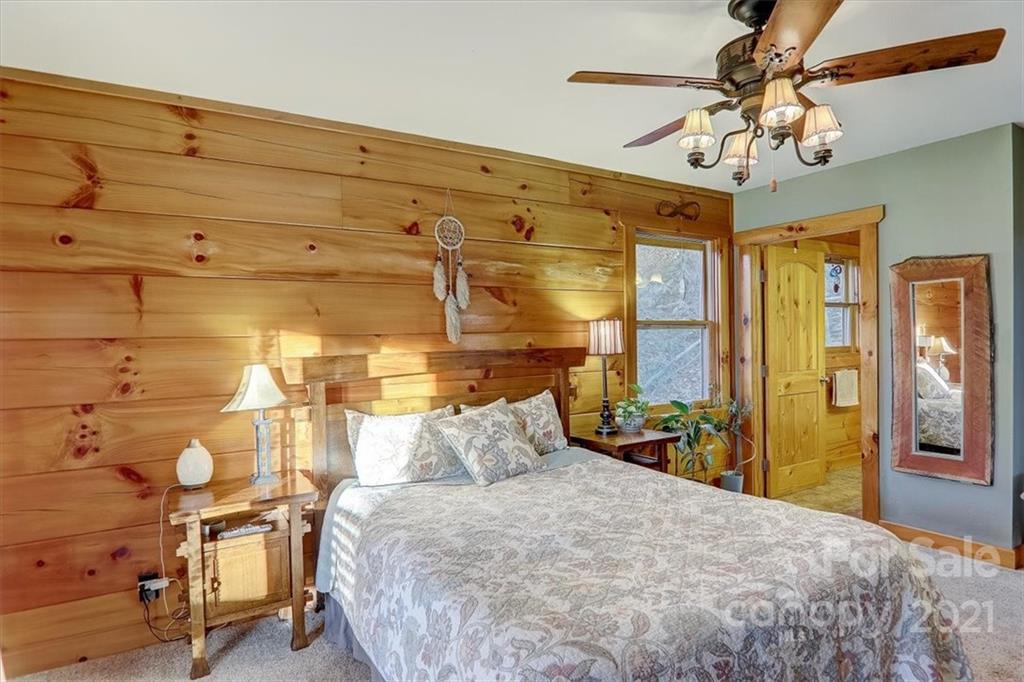 263 Summer Circle Clyde, NC 28721 - Photo 13 of 36 a bedroom with a bed and a chandelier