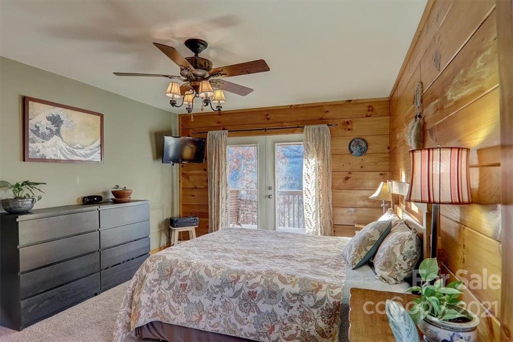 263 Summer Circle Clyde, NC 28721 - Photo 14 of 36 a bedroom with a bed and a chandelier