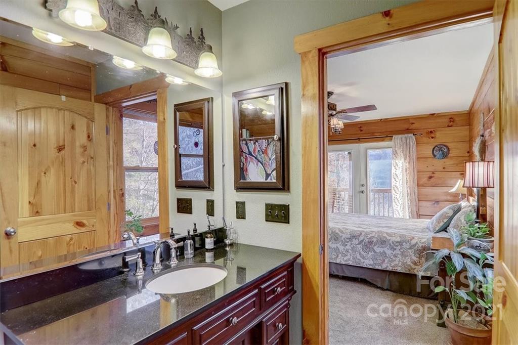 263 Summer Circle Clyde, NC 28721 - Photo 16 of 36 a en suite bathroom with a granite countertop tub sink a mirror and a shower