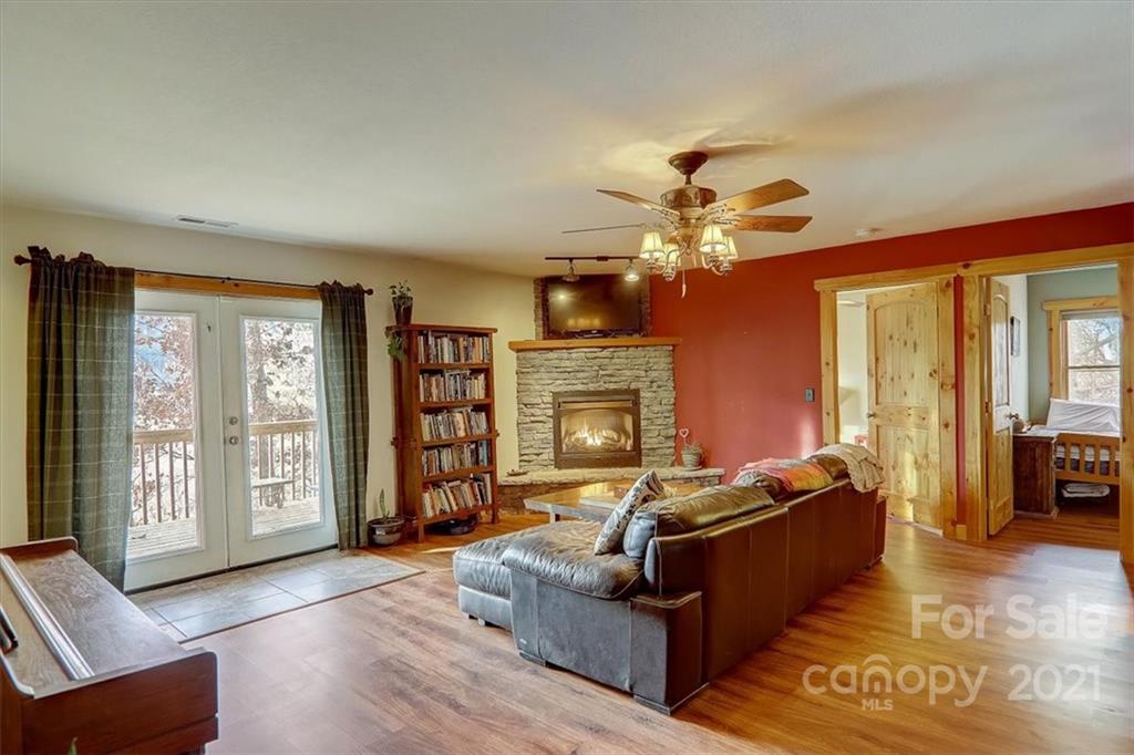 263 Summer Circle Clyde, NC 28721 - Photo 17 of 36 a living room with furniture a chandelier and a fireplace