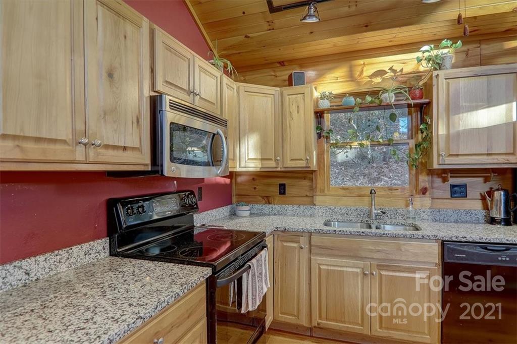 263 Summer Circle Clyde, NC 28721 - Photo 10 of 36 a kitchen with stainless steel appliances granite countertop a stove a sink and a microwave
