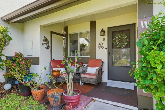 a front view of a house with outdoor seating and flowers
