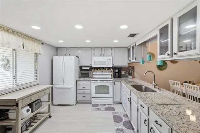 a bathroom with kitchen island granite countertop a sink and a mirror