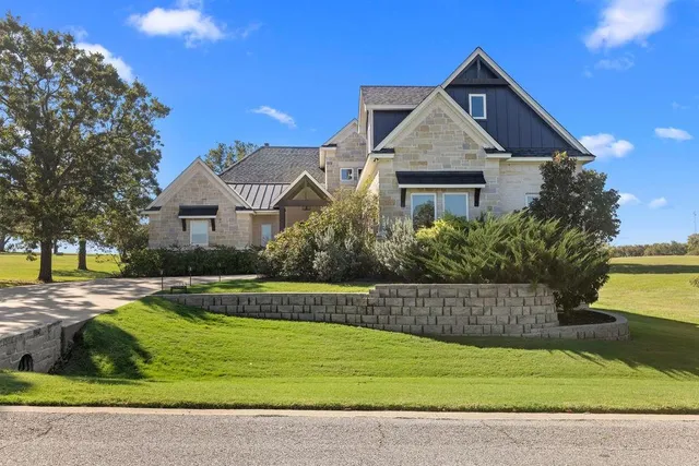 a front view of a house with a yard and trees