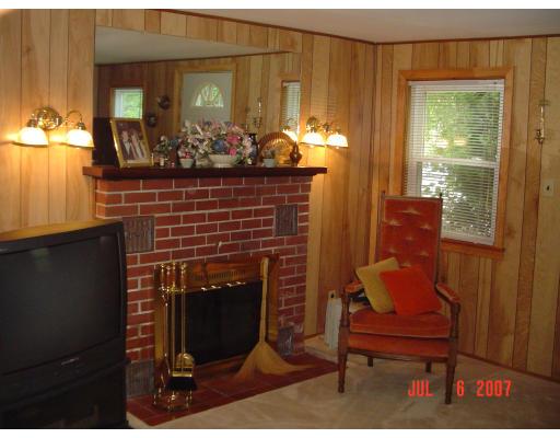 153 Swifts Beach Road Wareham, MA 02571 - Photo 7 of 9 a living room with furniture a chandelier and a fireplace