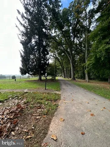 a white house with a big yard and large trees