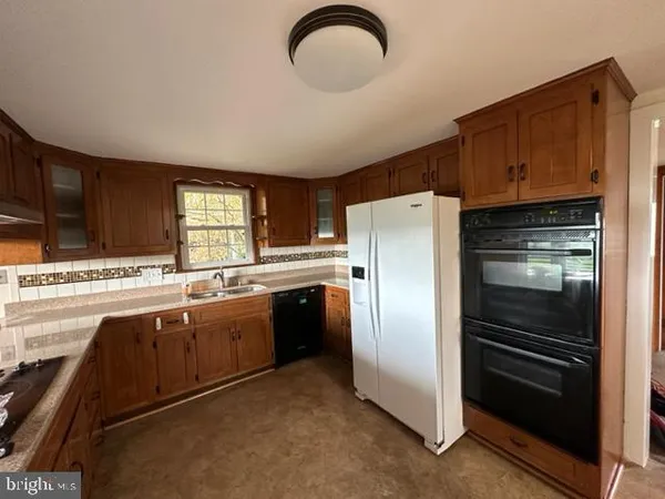 a kitchen with stainless steel appliances granite countertop a refrigerator and a stove top oven