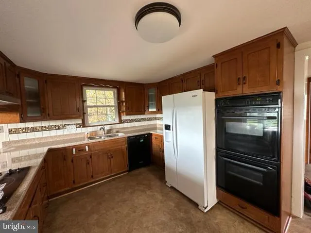 a kitchen with stainless steel appliances granite countertop a refrigerator and a stove top oven